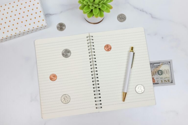 An organized workspace with a notebook, pen, and currency on a marble desk, ideal for finance planning.