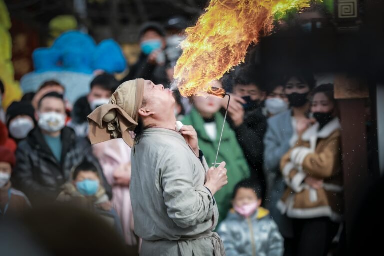 Fire performer entertains a crowd with fiery spectacle, capturing live audience reactions.